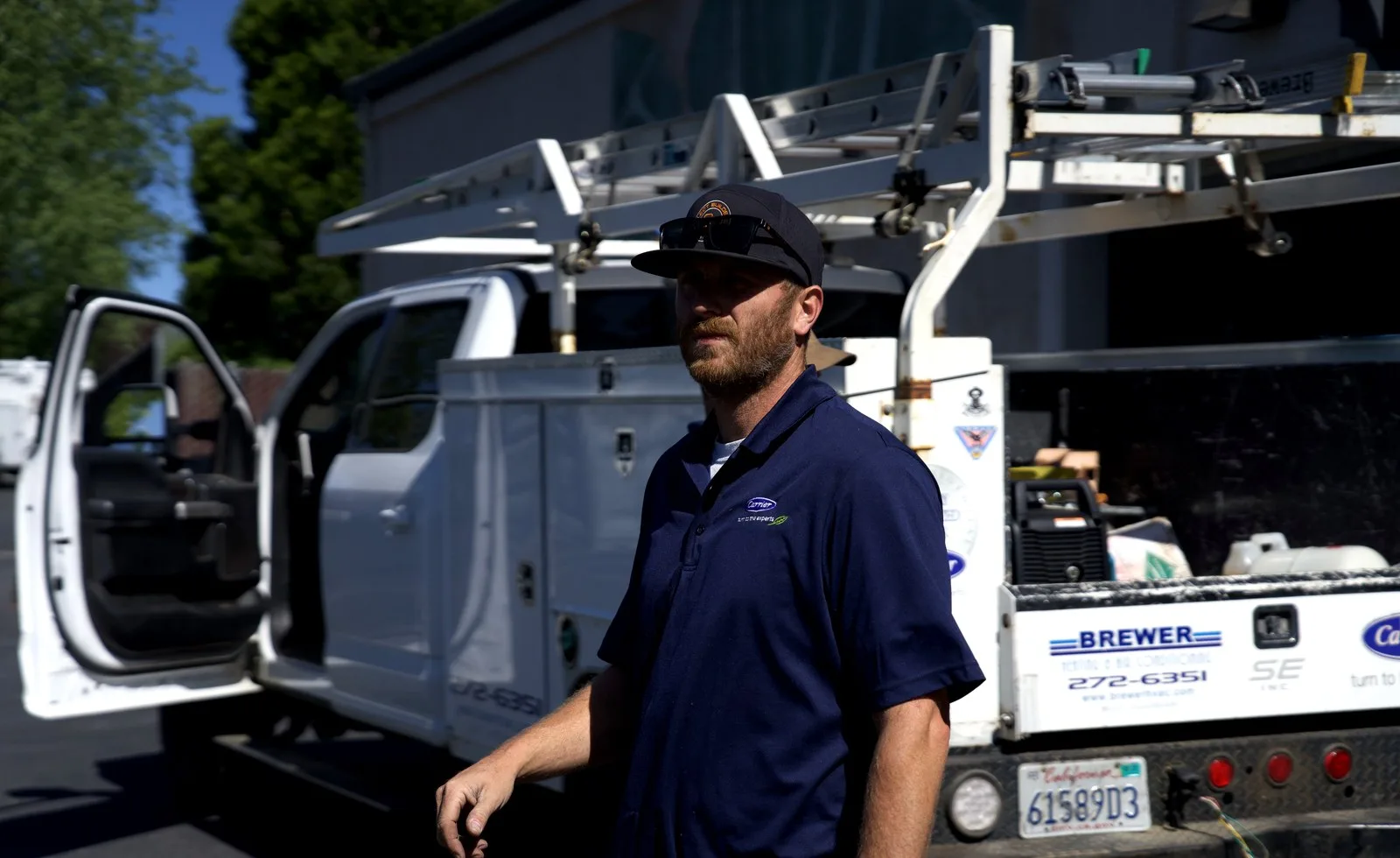 Brewer HVAC technician beside a stocked service truck
