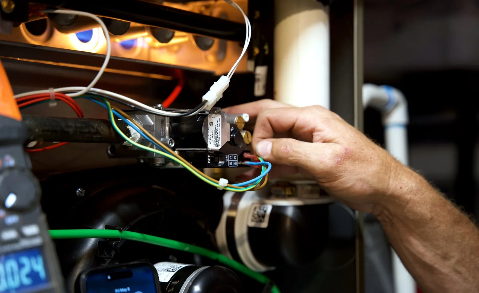 Close detail of furnace wiring and technician service work